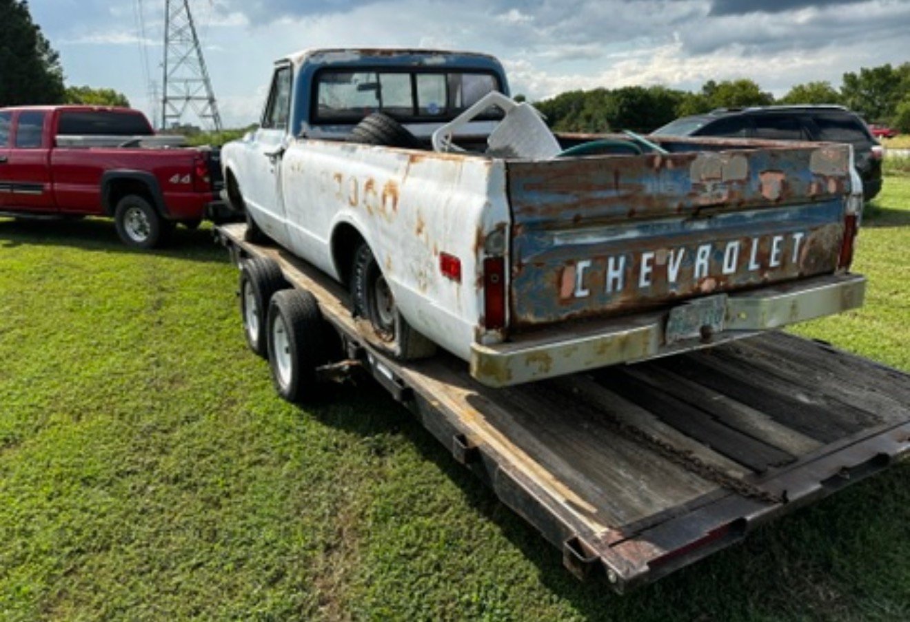 Older rusty Chevrolet pickup on a trailer
